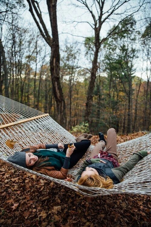 Two people lying in a hammock in an autumnal forrest, how to stay positive