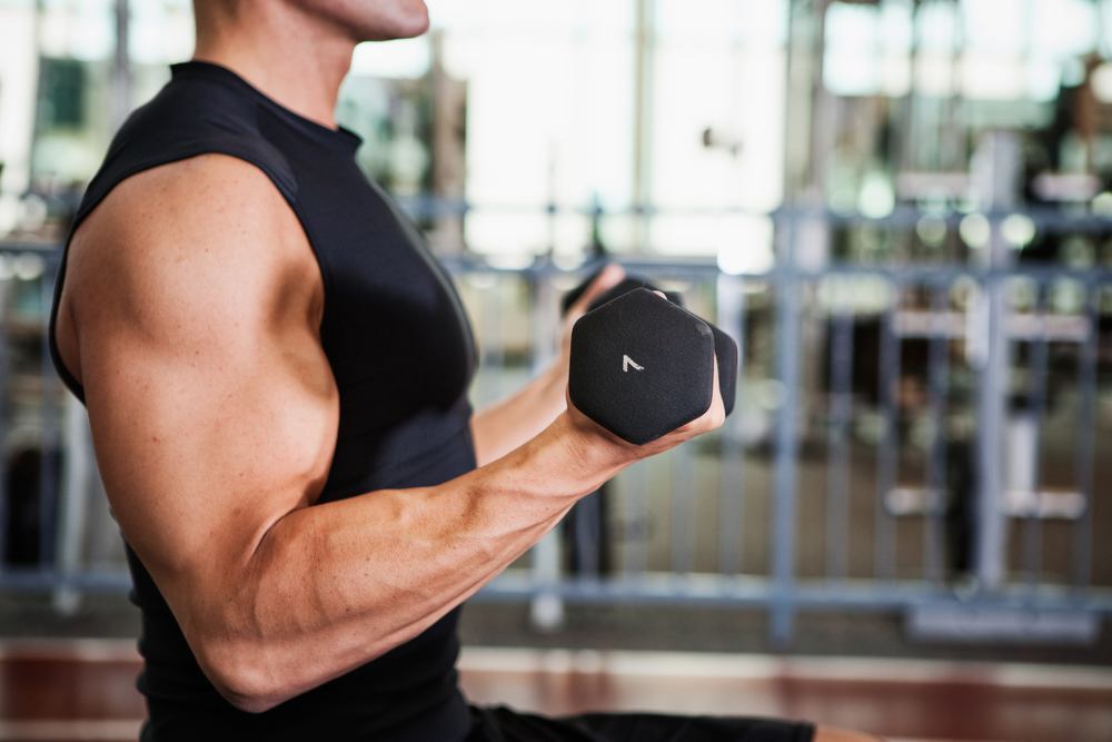 Profile view of person lifting weights in the gym