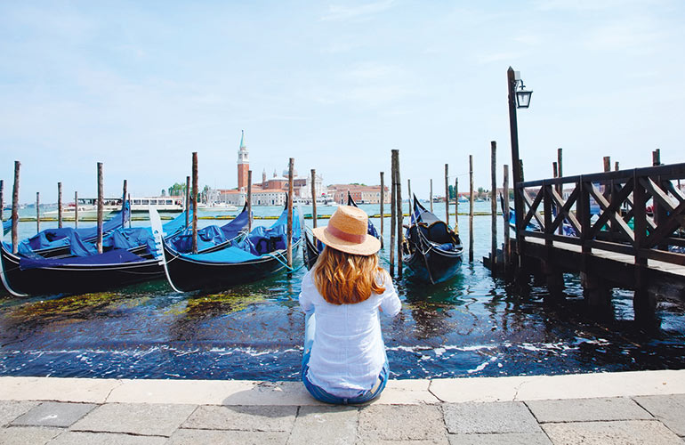 Woman sitting on marina promenade